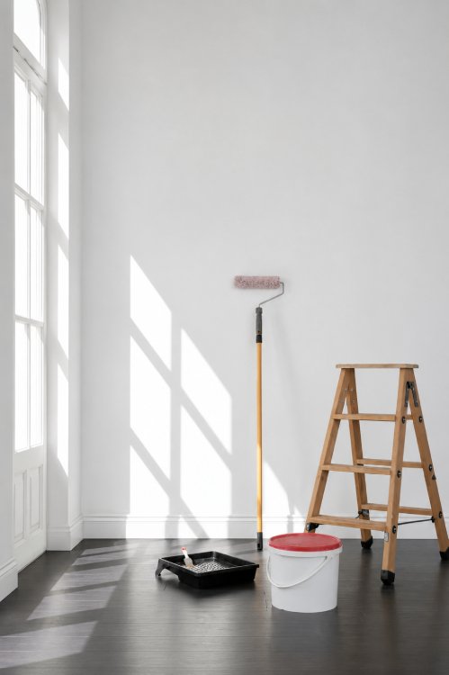 cuarto con cubeta de pintura, rodillo escalera listo para mantenimiento